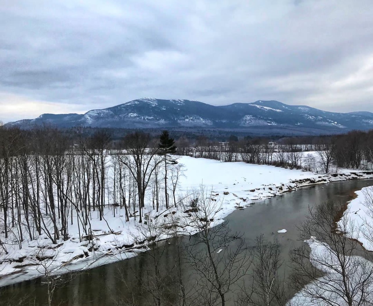 White Mountains, North Conway, NH in winter. Snow covered ground and river.